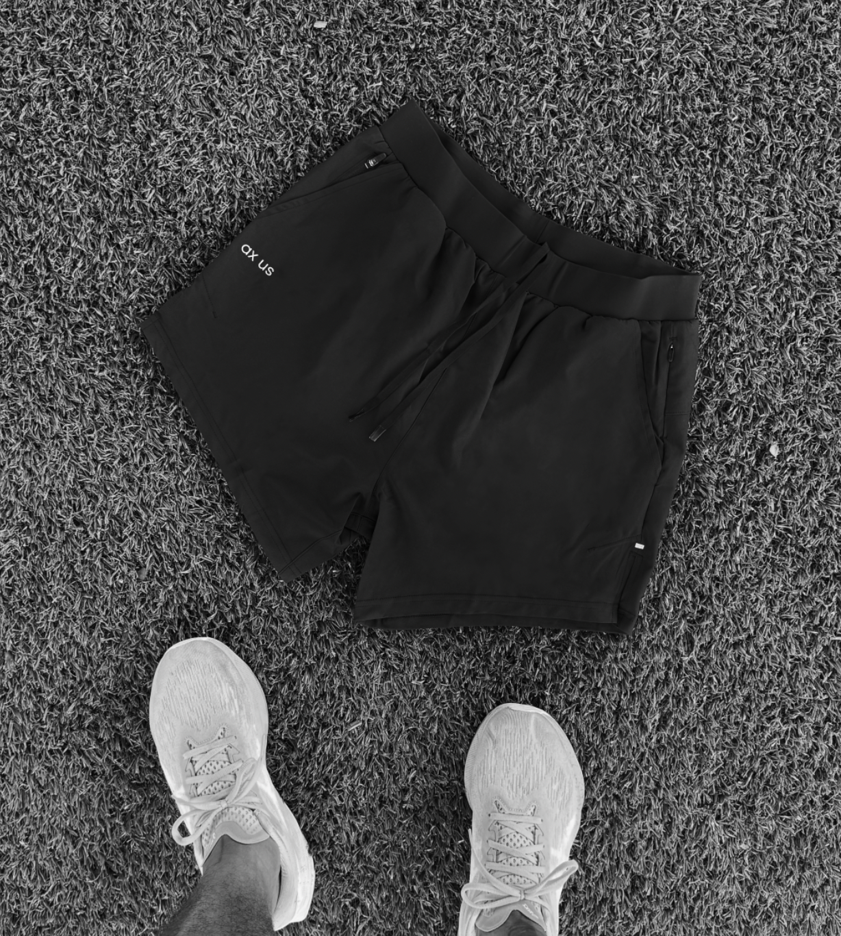 Person wearing black pants and white sneakers on a textured surface